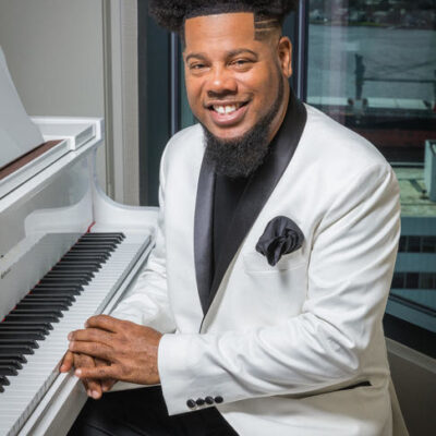 Dr. Earl Bynum seated at piano